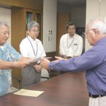 国保運営協の松川会長(左)から下地市長に国保税率を引き下げる条例の一部改正案が答申された=11日、市長室 国保運営協の松川会長(左)から下地市長に国保税率を引き下げる条例の一部改正案が答申された=11日、市長室