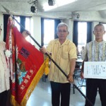 総合優勝した大木区の役員に賞状と優勝旗が下地村長(左)から授与された=25日、多良間村中央公民館 総合優勝した大木区の役員に賞状と優勝旗が下地村長(左)から授与された=25日、多良間村中央公民館